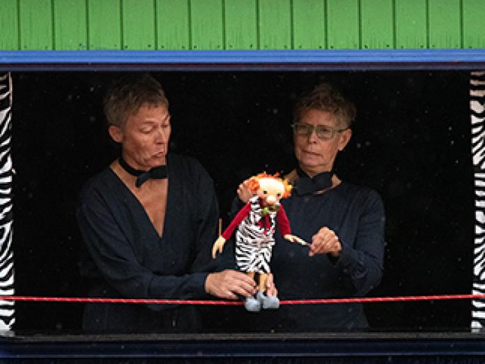 To kvinder og dukken Gustav spiller i Cirkusvognen