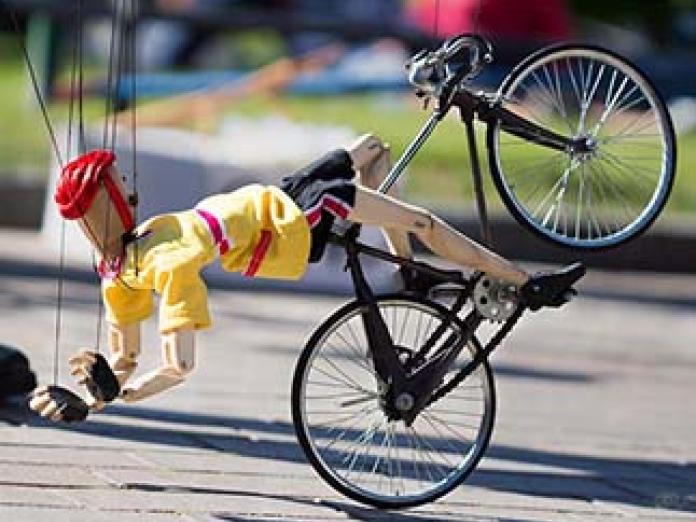 Dukke på dukkecykel. Fra fra 'Hanging by a thread' af Di Filippo Marionette