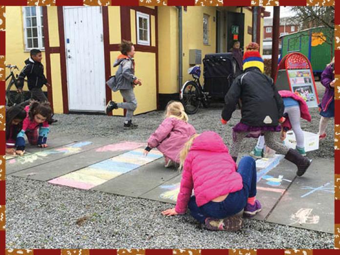 Børn leger og tegner med kridt foran Børnekulturhuset Sokkelundlille